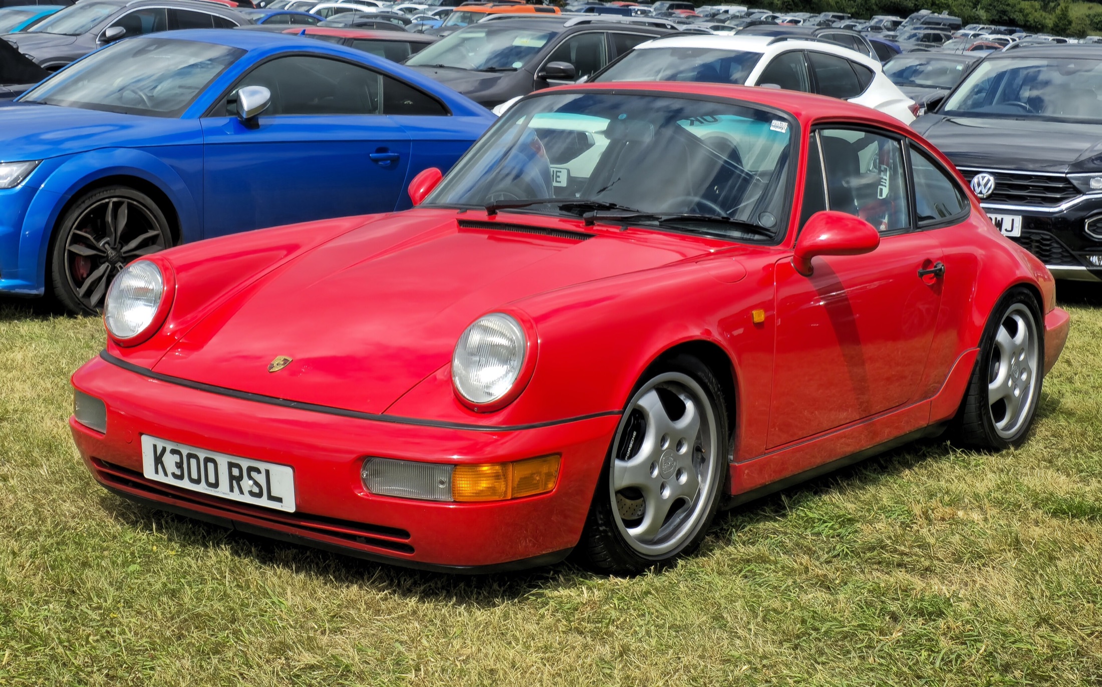 Roter Porsche 911 Carrera 2 der Baureihe 964 aus schräger Frontansicht
