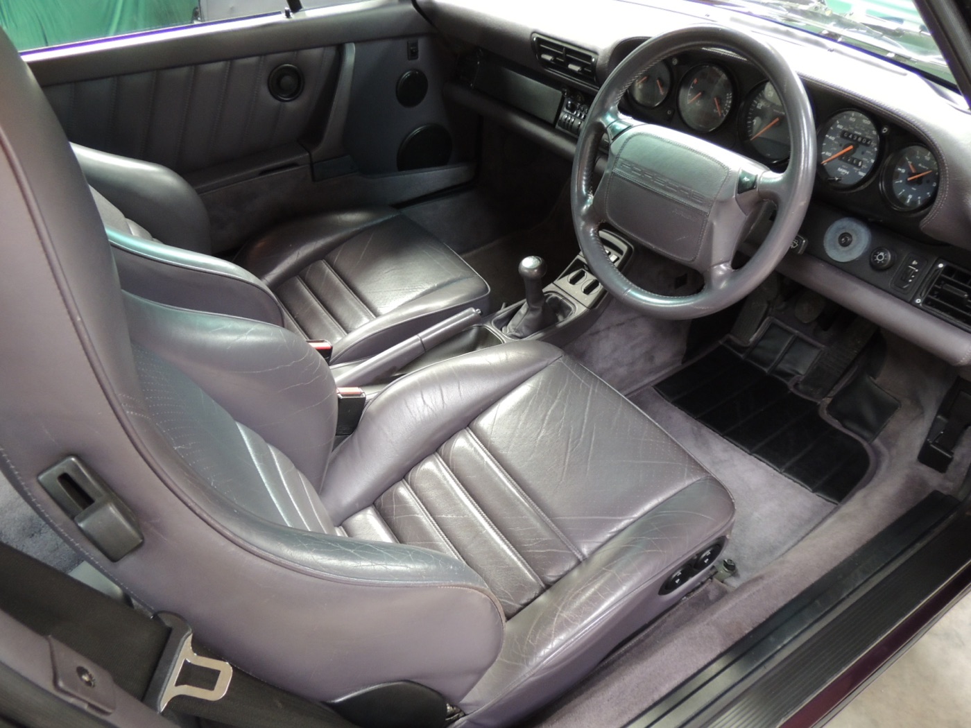 Innenraum eines rechtsgelenkten Porsche 911 Typ 964 mit Ledersitzen und Fünfgangschaltung